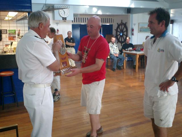 Commander Rex Edwards Presenting the Leander Trophy to Neill Wood and Steve Hogg. Presentation of the Leander Trophy to Neill Wood and Steve Hogg by Commander Rex Edwards, HMNZS Pegasus, at the 53rd Leander Trophy Contest.